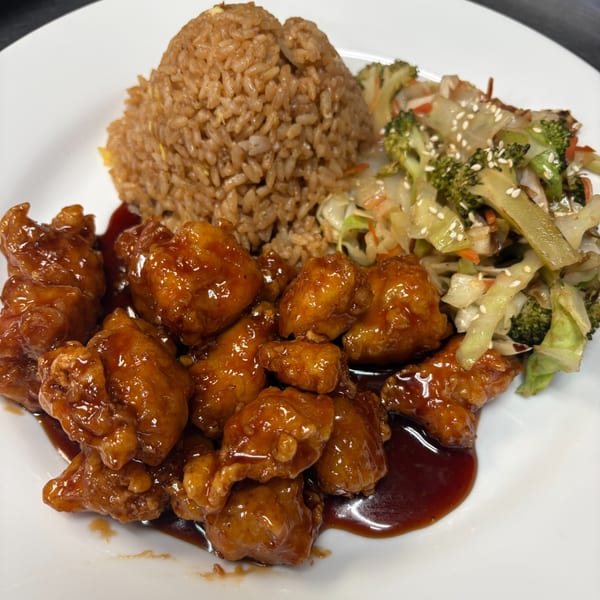 Okinawa's Japanese dish with glazed chicken, fried rice, and stir-fried vegetables with sesame seeds.